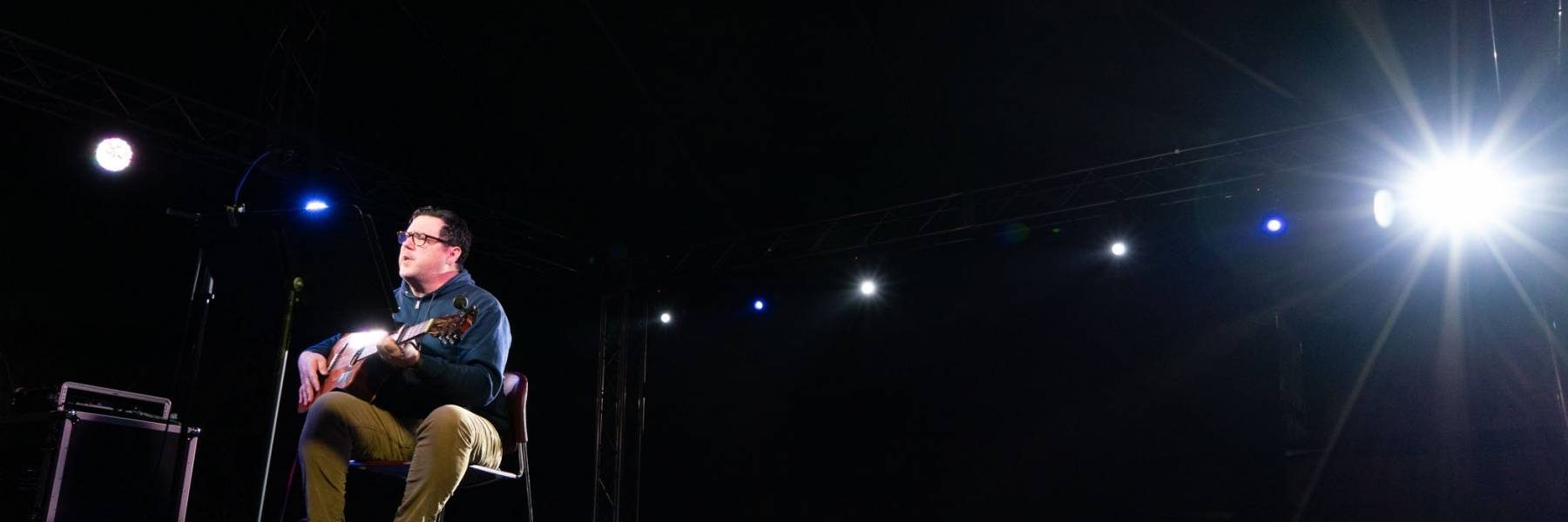 Image of musician performing on stage with guitar