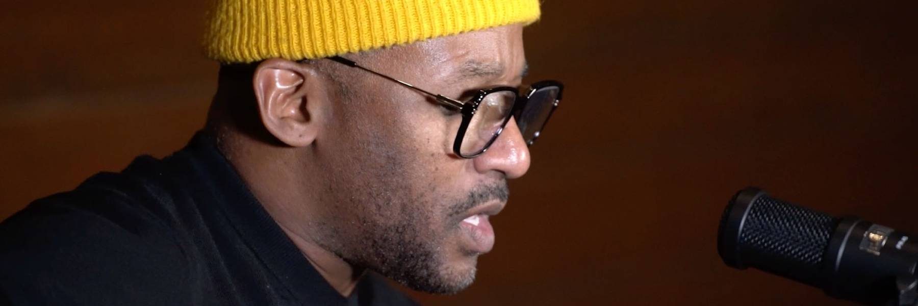 Photo of a man, Redray Frazier, in front of microphone.