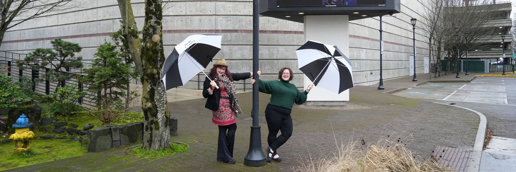 Two women under an umbrella with logo 