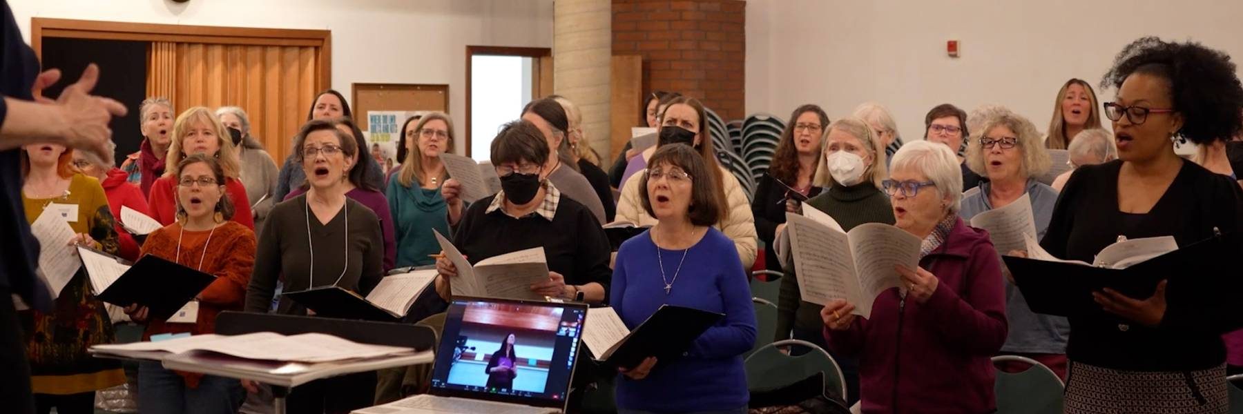 A behind the scenes picture image of the Eugene Concert Choir's performance of Black is Beautiful showcasing singers performing
